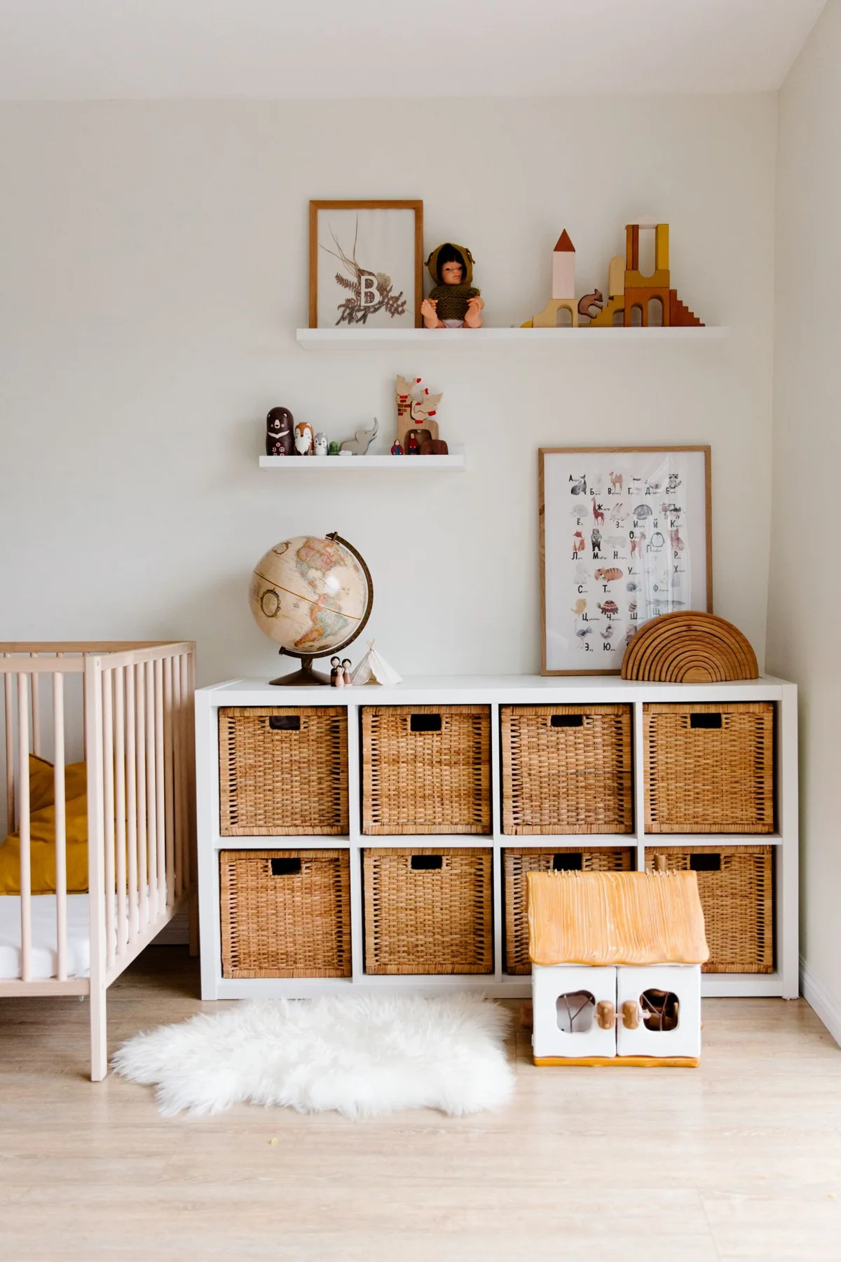 A nursery with a pale rug and woven storage baskets