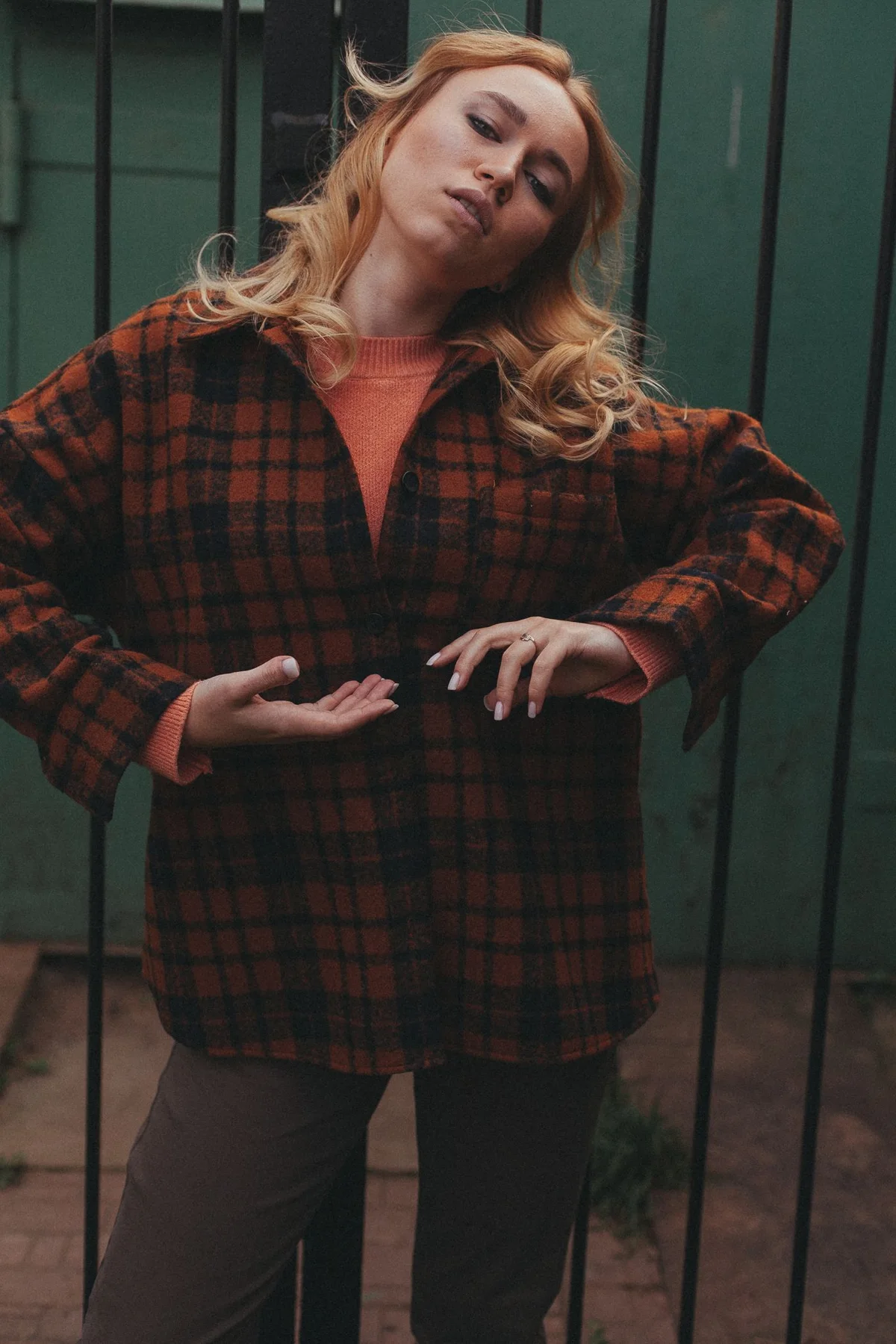 A woman wearing a dark red and black checkered overshirt outdoors