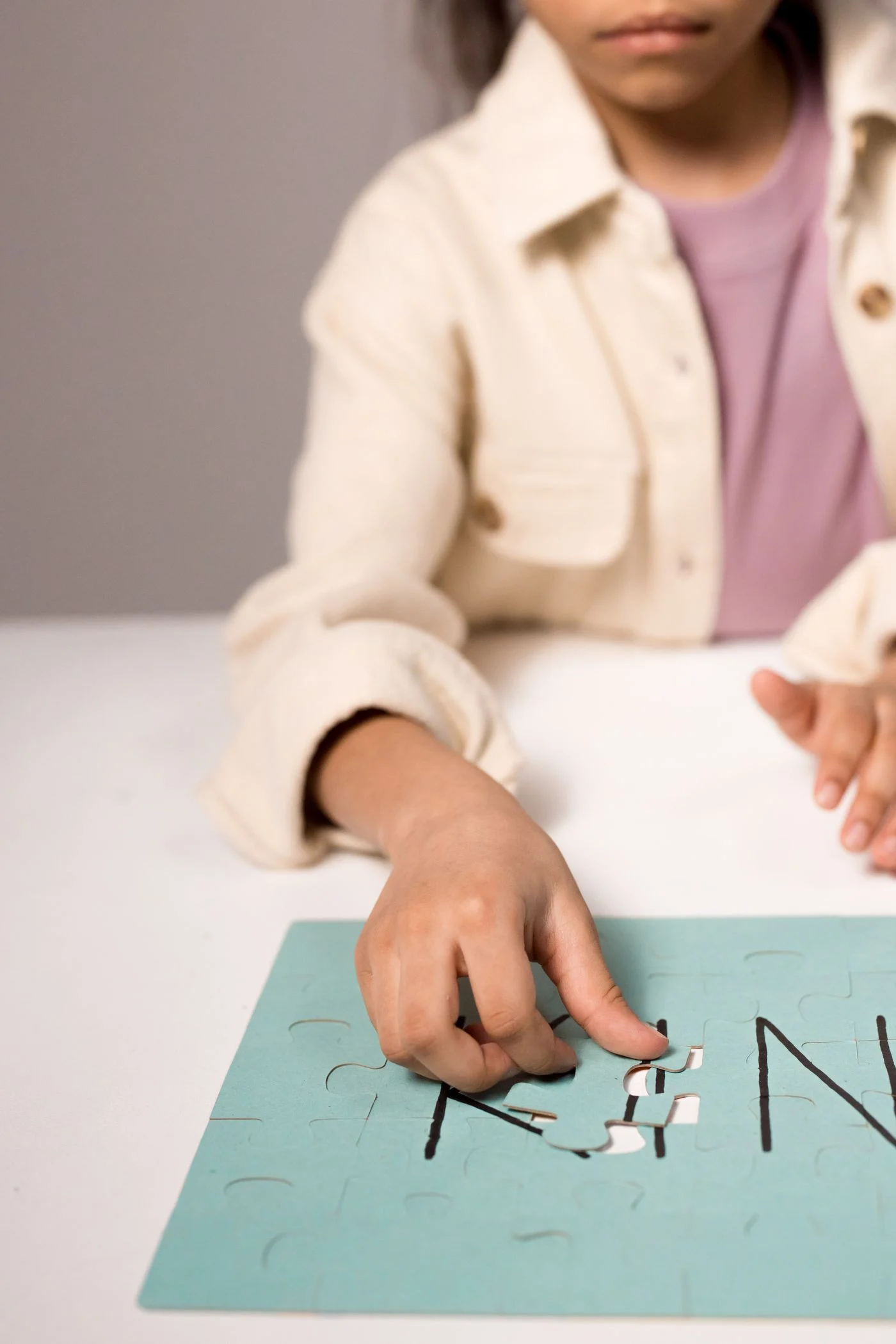 Close view of a child working with puzzle pieces