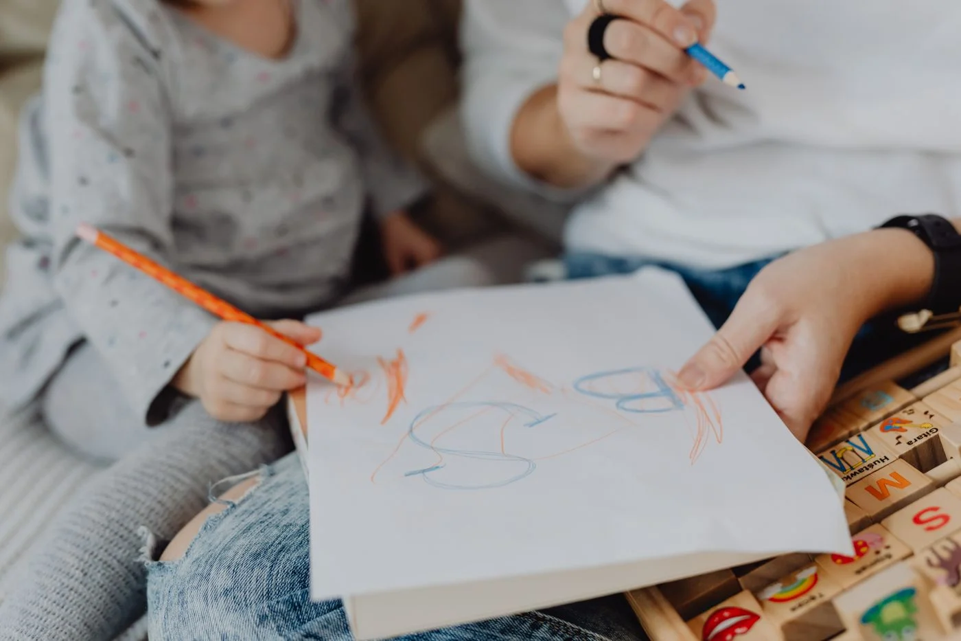 Adult and child drawing together with crayons