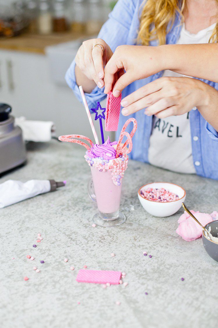 These Epic Royal Crazy milkshakes are indulgently MAGICAL! A rich, thick strawberry milkshake is topped with a sugaring of sprinkles and candies to make a delicious drink fit for a princess... or a prince. A pretty in pink and purple freak shake!