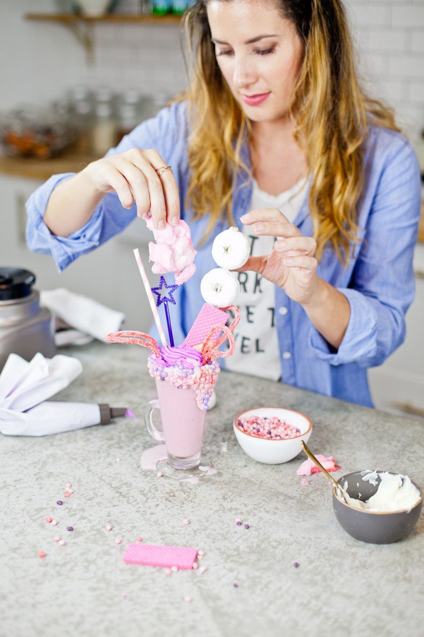 These Epic Royal Crazy milkshakes are indulgently MAGICAL! A rich, thick strawberry milkshake is topped with a sugaring of sprinkles and candies to make a delicious drink fit for a princess... or a prince. A pretty in pink and purple freak shake!