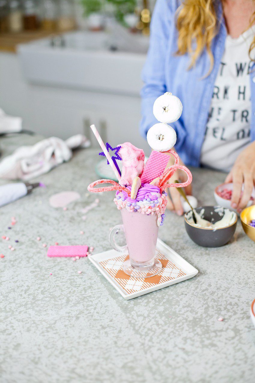 These Epic Royal Crazy shakes are indulgently MAGICAL! A rich, thick strawberry milkshake is topped with a sugaring of sprinkles and candies to make a delicious crazy shake drink fit for a princess... or a prince. A pretty in pink and purple freak shake!
