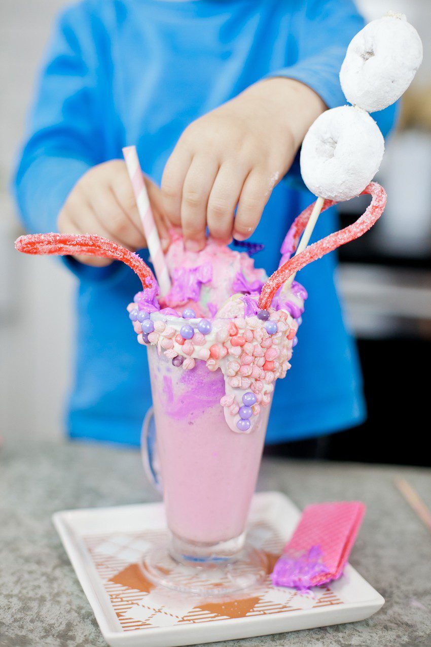 These Epic Royal Crazy shakes are indulgently MAGICAL! A rich, thick strawberry milkshake is topped with a sugaring of sprinkles and candies to make a delicious crazy shake drink fit for a princess... or a prince. A pretty in pink and purple freak shake!