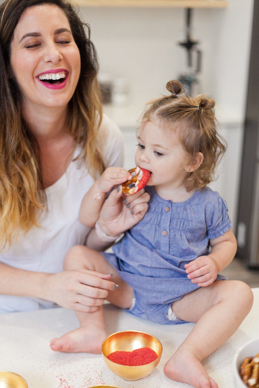 A simple and easy Valentine's Day chocolate dipped pretzels treat, that you can make with and for your kids (they look like they took more effort than they really do!), by Tabitha Blue of Fresh Mommy Blog - Valentines Day Lovely Chocolate Dipped Pretzels by popular Florida lifestyle blogger Fresh Mommy Blog