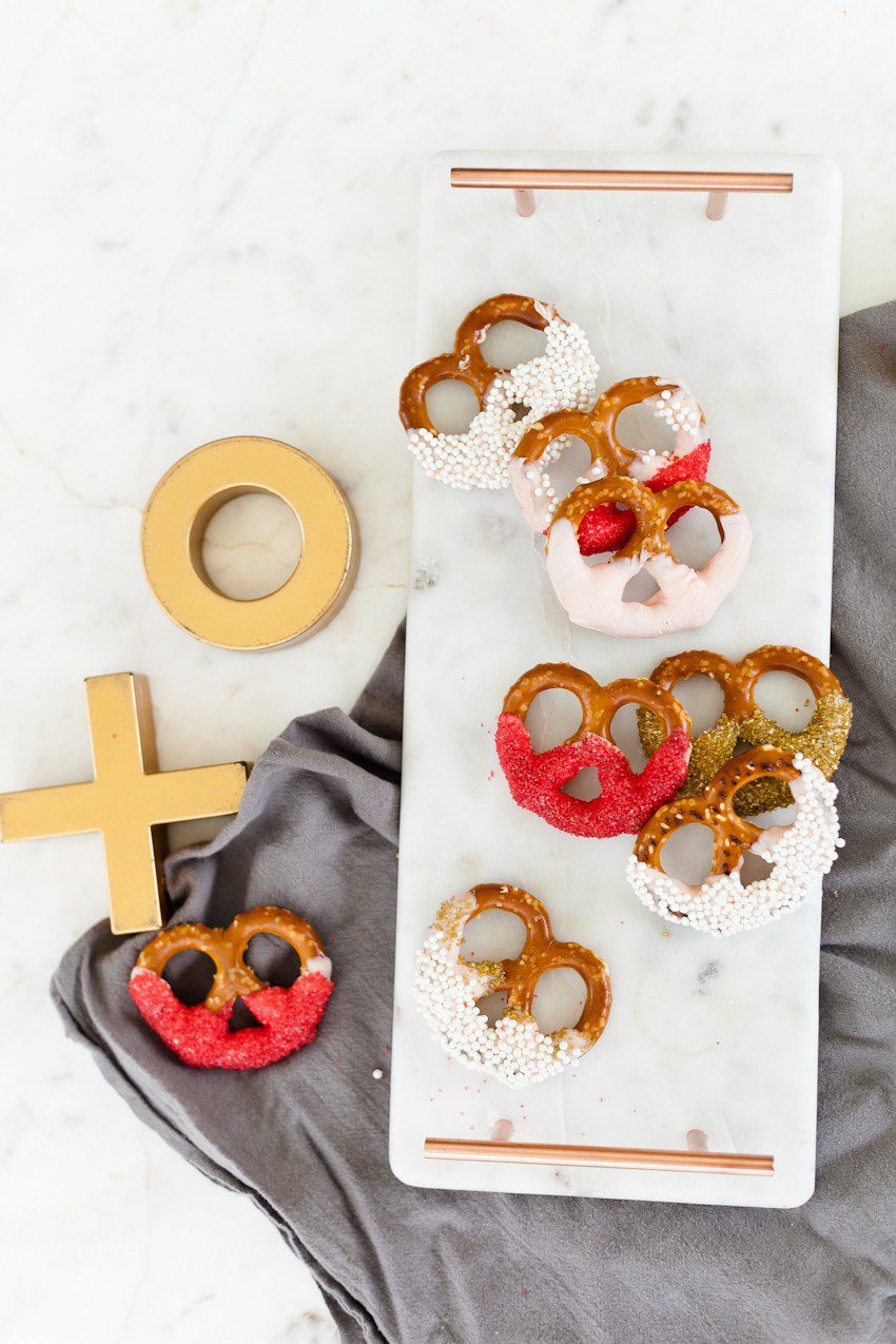 A simple and easy Valentine's Day chocolate dipped pretzels treat, that you can make with and for your kids (they look like they took more effort than they really do!), by Tabitha Blue of Fresh Mommy Blog - Valentines Day Lovely Chocolate Dipped Pretzels by popular Florida lifestyle blogger Fresh Mommy Blog