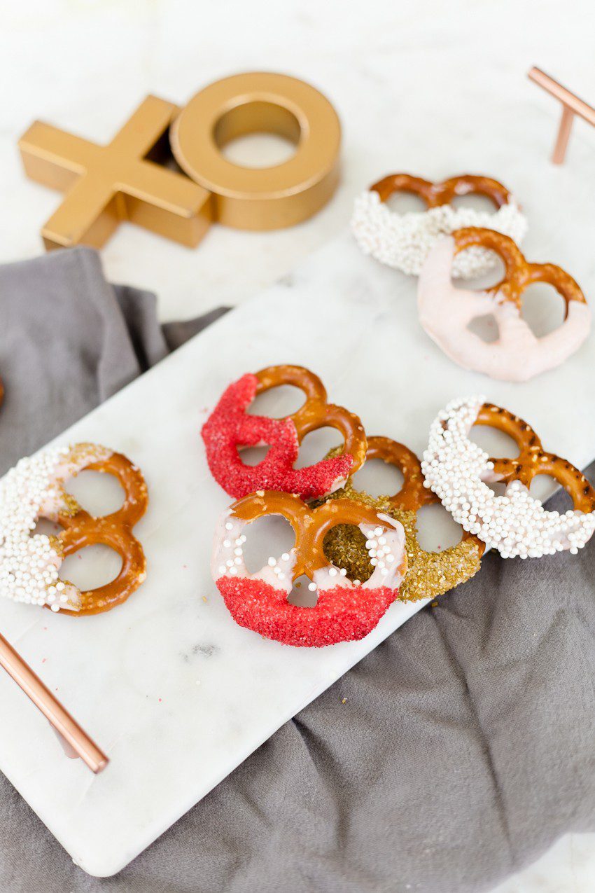 A simple and easy Valentine's Day chocolate dipped pretzels treat, that you can make with and for your kids (they look like they took more effort than they really do!), by Tabitha Blue of Fresh Mommy Blog - Valentines Day Lovely Chocolate Dipped Pretzels by popular Florida lifestyle blogger Fresh Mommy Blog