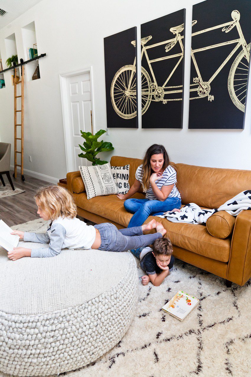 Seeing past dated paint colors, a wall of mirrors, popcorn ceiling and mismatched flooring, this ultimate living room has been completely transformed to a cozy and comfortable open family living space with bold statement pieces like our Article sofa, neutral colors and touches of sleek mid century and Scandinavian inspired design. The ultimate living room makeover before and after for a busy family from popular Florida lifestyle blogger Tabitha Blue of Fresh Mommy Blog. | Article sofa featured in the latest living room makeover by top Florida lifestyle blog, Fresh Mommy Blog
