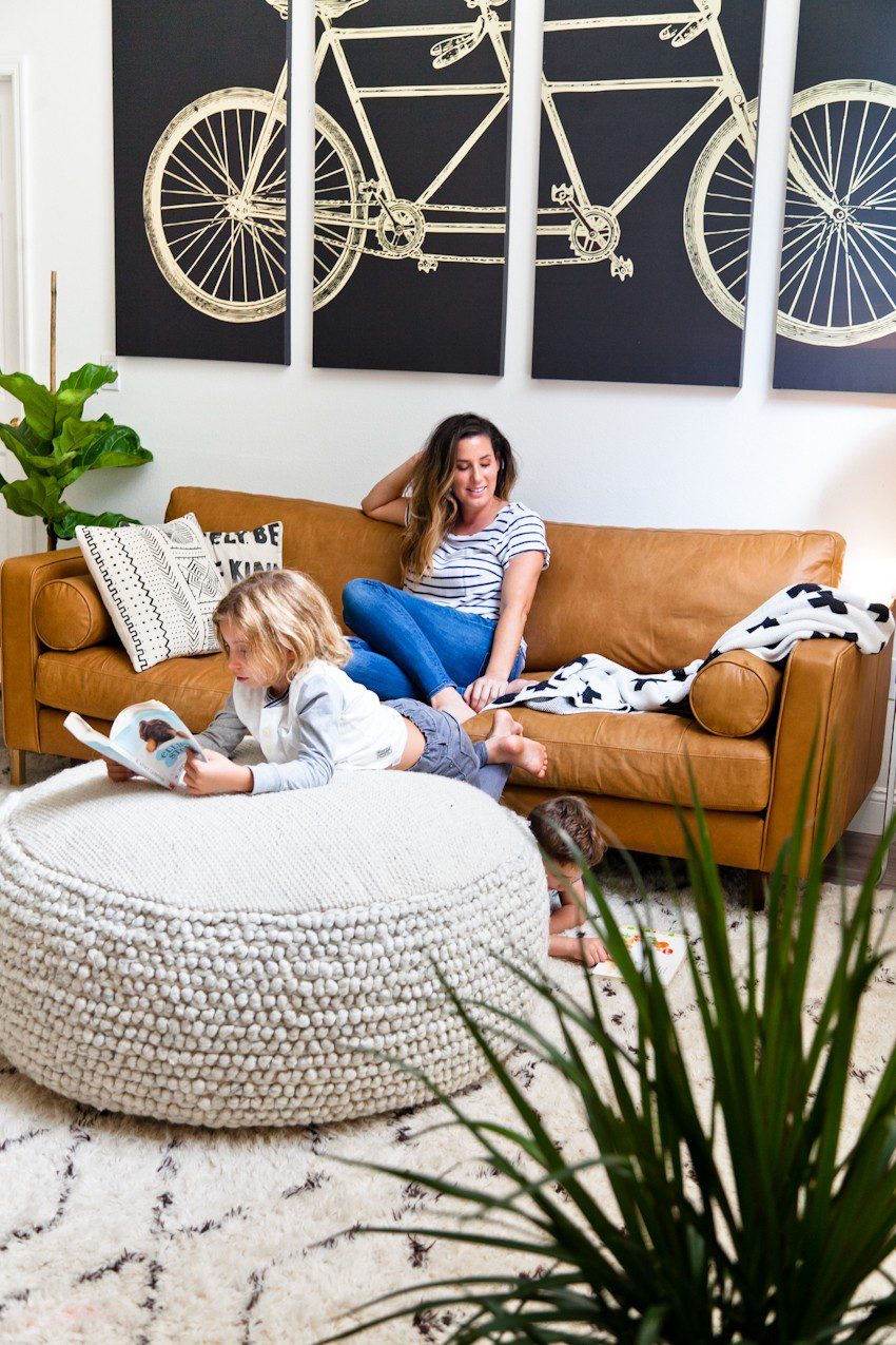 Seeing past dated paint colors, a wall of mirrors, popcorn ceiling and mismatched flooring, this ultimate living room has been completely transformed to a cozy and comfortable open family living space with bold statement pieces like our Article sofa, neutral colors and touches of sleek mid century and Scandinavian inspired design. The ultimate living room makeover before and after for a busy family from popular Florida lifestyle blogger Tabitha Blue of Fresh Mommy Blog. | Article sofa featured in the latest living room makeover by top Florida lifestyle blog, Fresh Mommy Blog