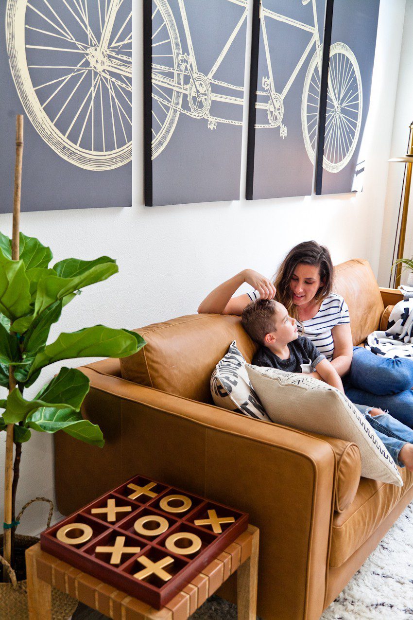 Seeing past dated paint colors, a wall of mirrors, popcorn ceiling and mismatched flooring, this ultimate living room has been completely transformed to a cozy and comfortable open family living space with bold statement pieces like our Article sofa, neutral colors and touches of sleek mid century and Scandinavian inspired design. The ultimate living room makeover before and after for a busy family from popular Florida lifestyle blogger Tabitha Blue of Fresh Mommy Blog. | Article sofa featured in the latest living room makeover by top Florida lifestyle blog, Fresh Mommy Blog