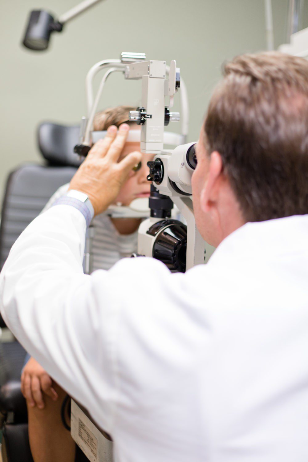 Back to School Eye Exam: How to Prepare your Child for a Successful Academic Year | Back to School Eye Exam: How to Prepare your Child for a Successful Academic Year by popular Florida lifestyle blog, Fresh Mommy Blog: image of a young boy getting his eyes examined by an eye doctor.