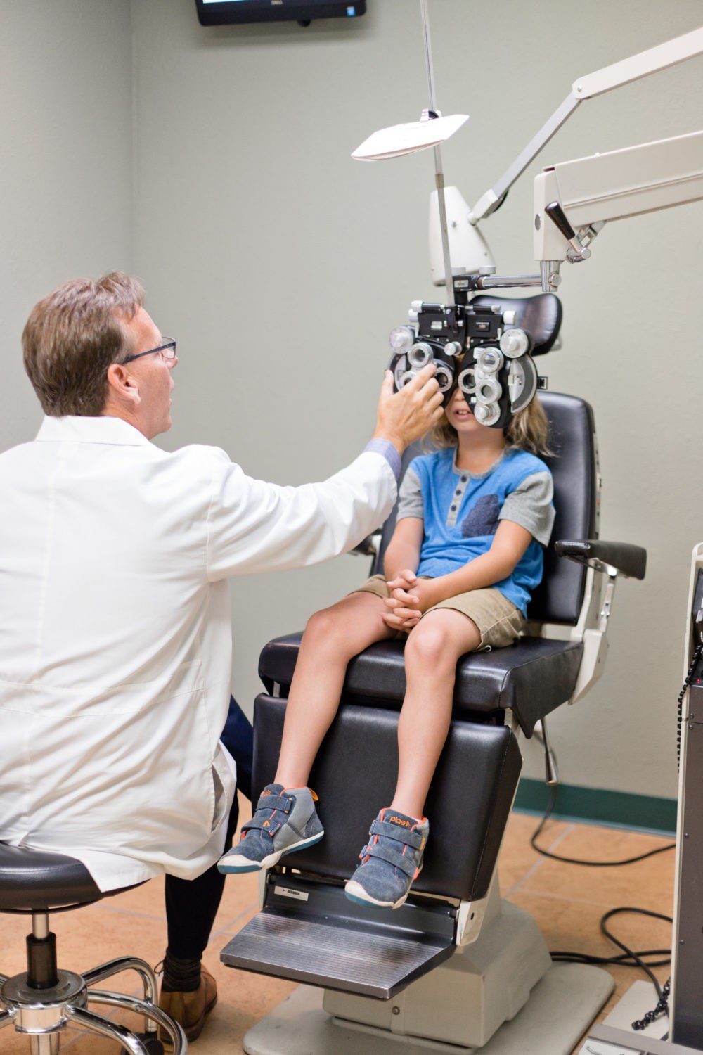 Back to School Eye Exam: How to Prepare your Child for a Successful Academic Year | Back to School Eye Exam: How to Prepare your Child for a Successful Academic Year by popular Florida lifestyle blog, Fresh Mommy Blog: image of a young boy getting his eyes examined by an eye doctor.