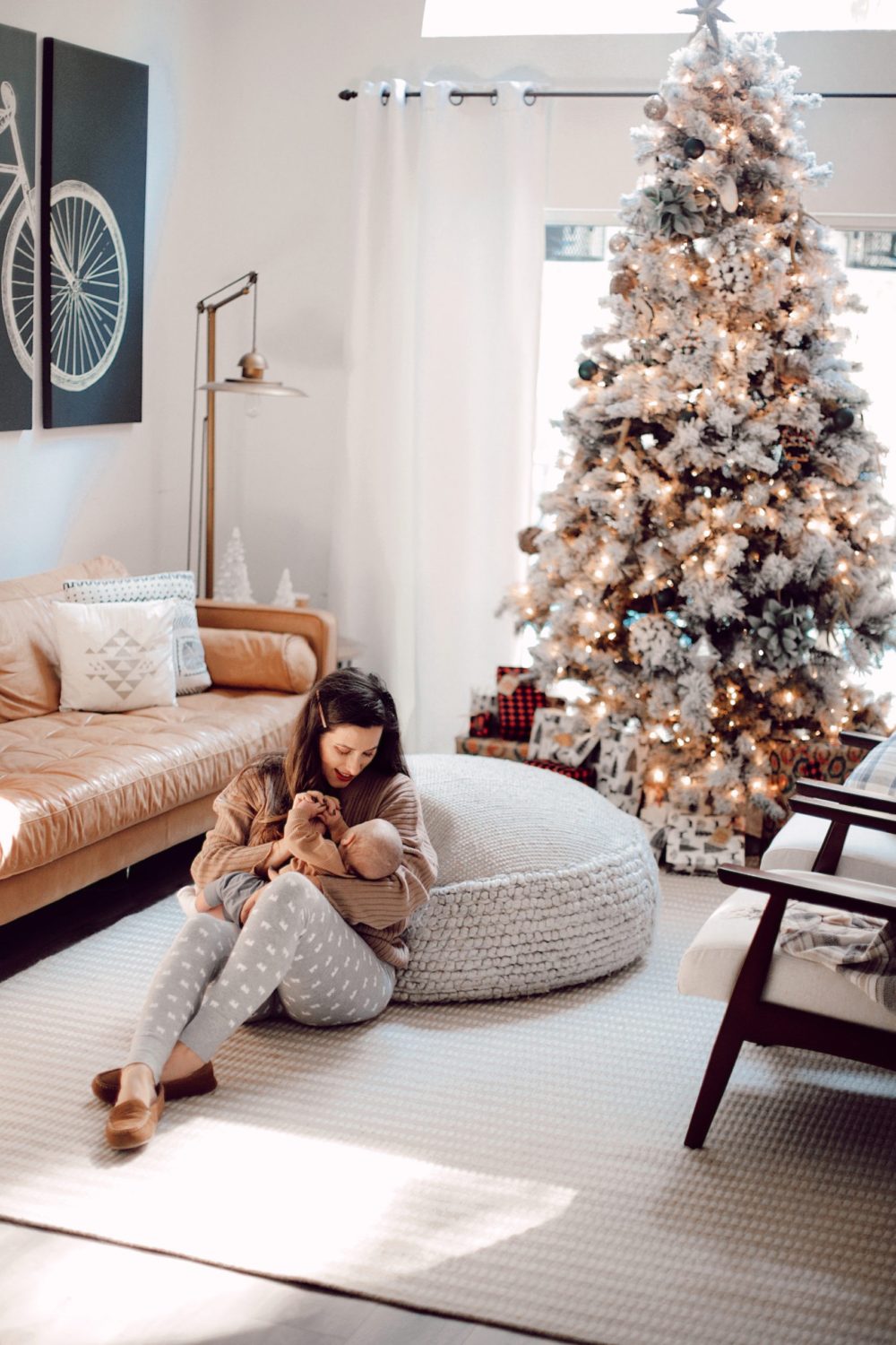 7 Geniously Efficient Mom Hacks for Home Design | 7 Genius Efficient Home Design Hacks for Moms by popular Florida life and style blog, Fresh Mommy Blog: image of a mom sitting on the floor in her living room and holding her new born baby.