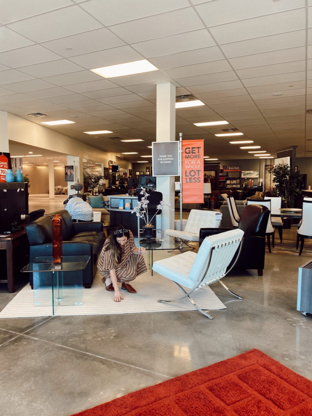 7 Geniously Efficient Mom Hacks for Home Design | 7 Genius Efficient Home Design Hacks for Moms by popular Florida life and style blog, Fresh Mommy Blog: image of a mom looking at a rug at CORT furniture outlet. 