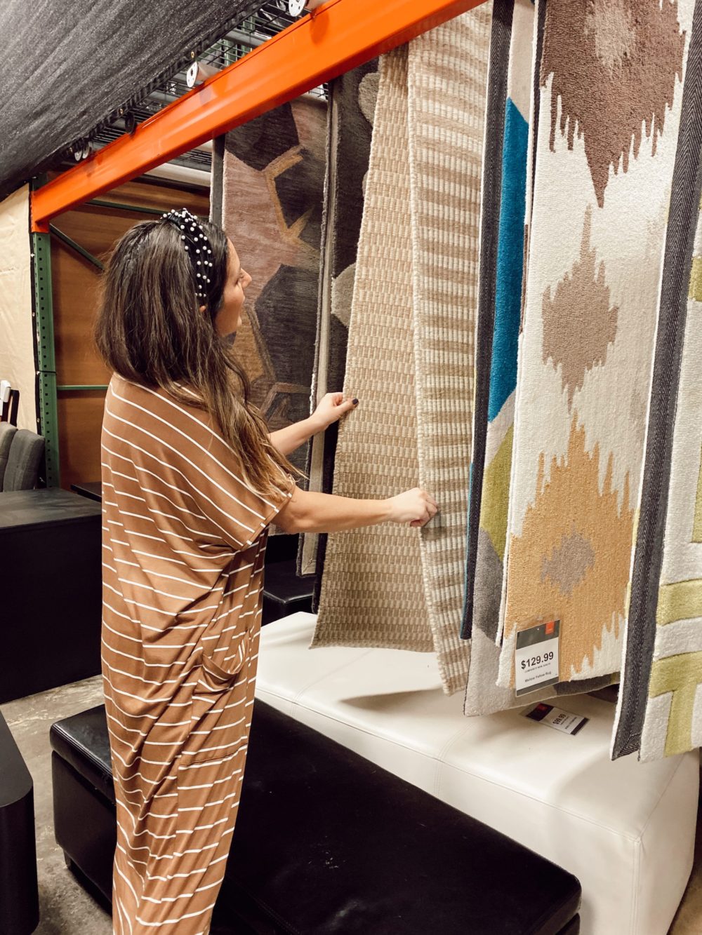 7 Genius Efficient Home Design Hacks for Moms by popular Florida life and style blog, Fresh Mommy Blog: image of a mom looking at rugs at CORT Furniture Outlet.