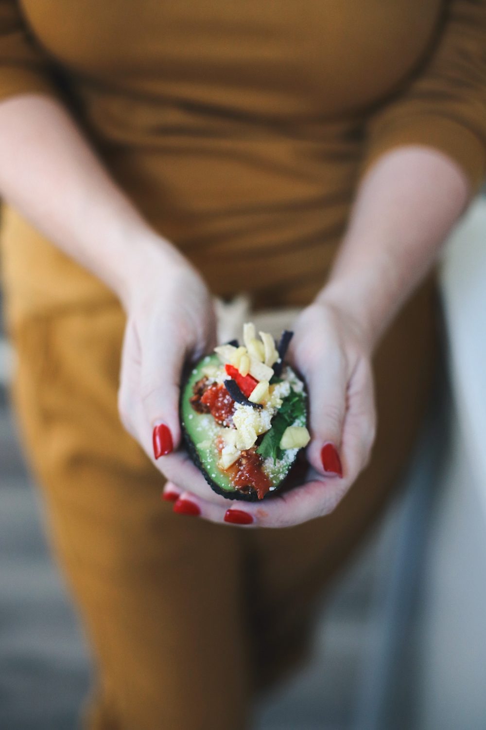 Avocado Keto Taco Bowls recipe featured by top Florida lifestyle blog, Fresh Mommy Blog: Easy Entertaining with Make-Your-Own Avo Taco Bowls | Keto Taco Bowls by popular Florida lifestyle blog, Fresh Mommy Blog: image of a woman holding a keto taco bowl in her hands.