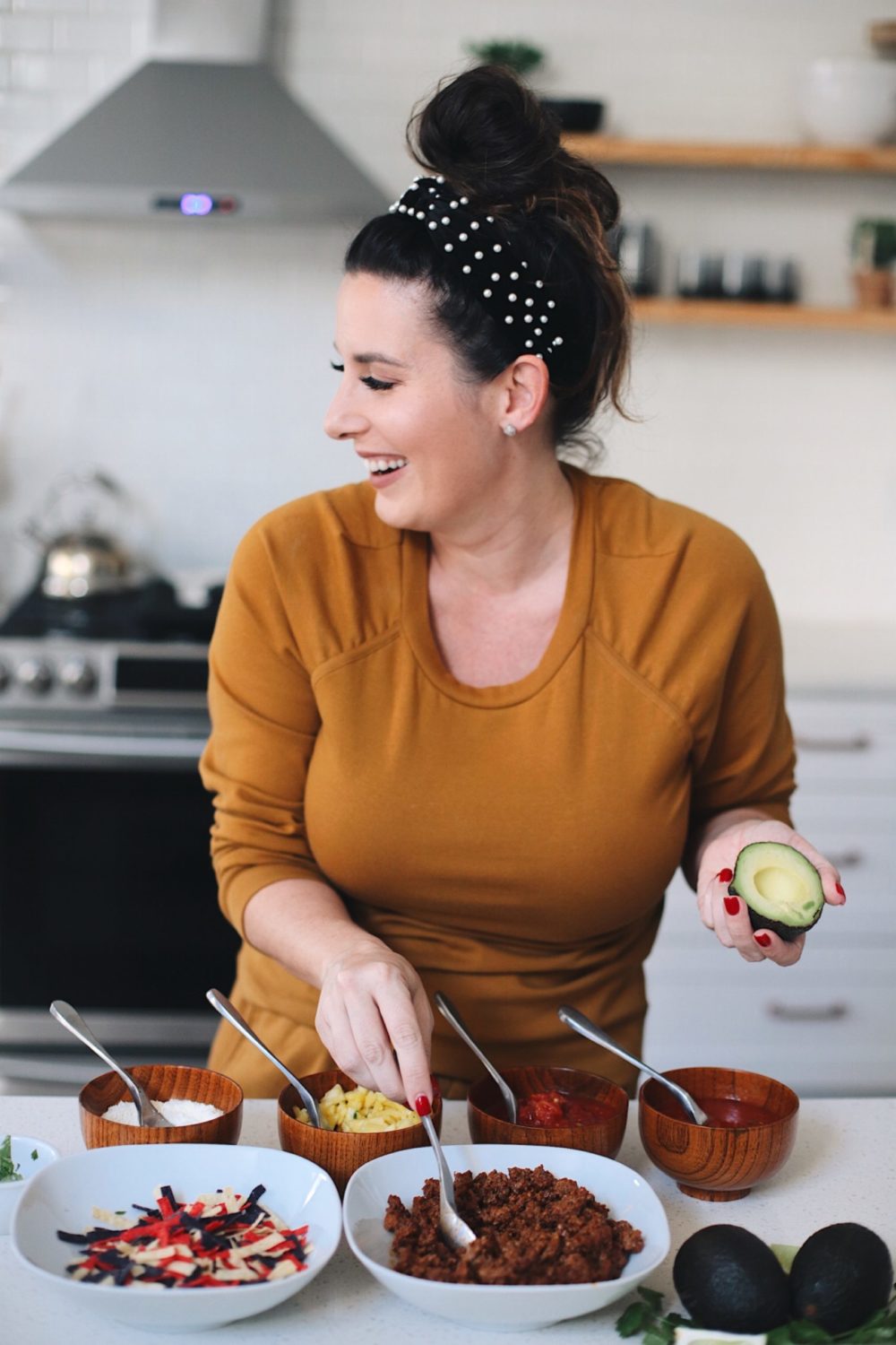 Avocado Keto Taco Bowls recipe featured by top Florida lifestyle blog, Fresh Mommy Blog: Easy Entertaining with Make-Your-Own Avo Taco Bowls | Keto Taco Bowls by popular Florida lifestyle blog, Fresh Mommy Blog: image of woman making keto taco bowls.