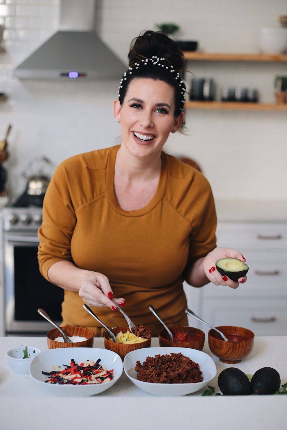 Avocado Keto Taco Bowls recipe featured by top Florida lifestyle blog, Fresh Mommy Blog: Easy Entertaining with Make-Your-Own Avo Taco Bowls | Keto Taco Bowls by popular Florida lifestyle blog, Fresh Mommy Blog: image of a woman making keto taco bowls.