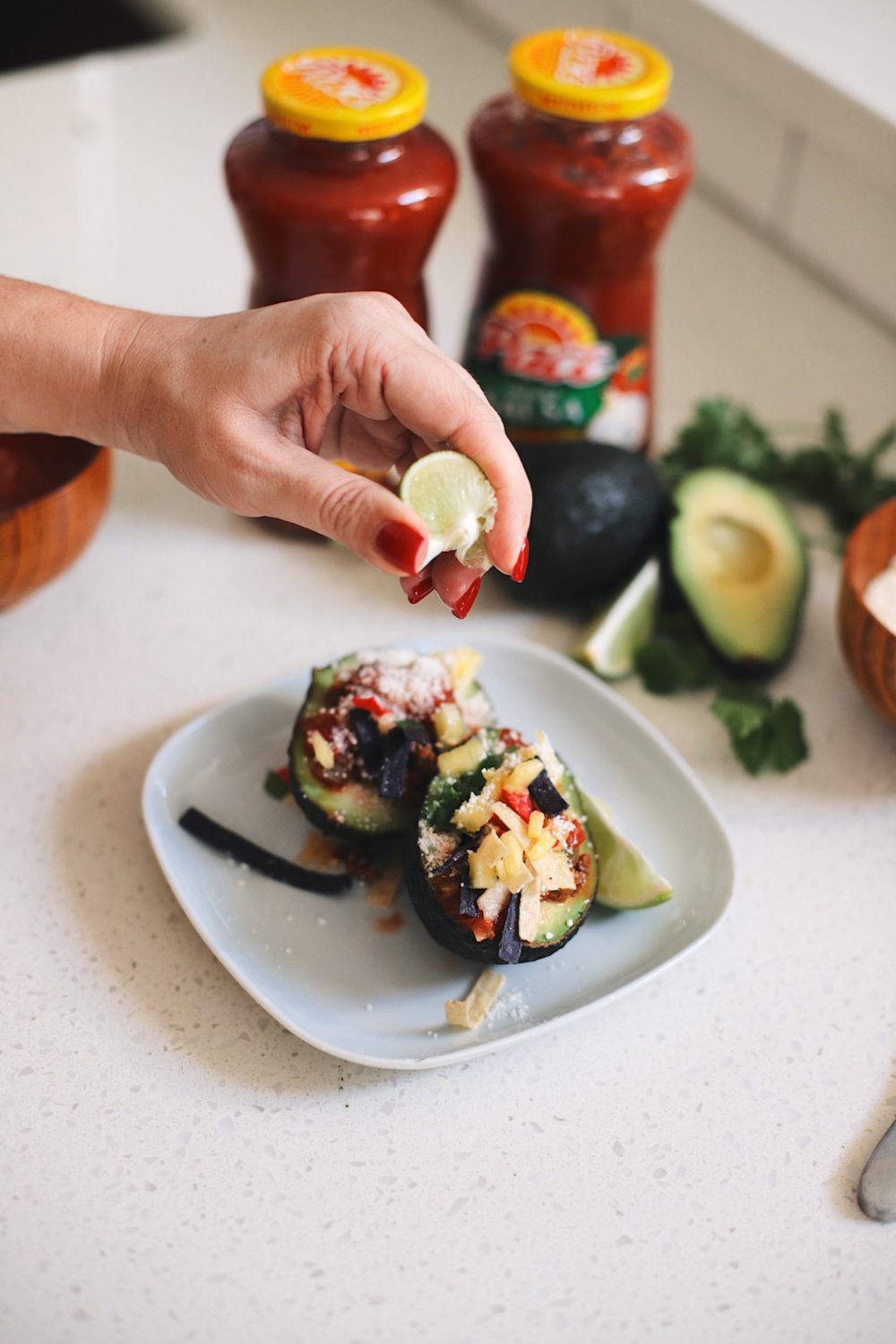 Avocado Keto Taco Bowls recipe featured by top Florida lifestyle blog, Fresh Mommy Blog: Easy Entertaining with Pace Chunky Salsa and Make-Your-Own Avo Taco Bowls | Keto Taco Bowls by popular Florida lifestyle blog, Fresh Mommy Blog: image of a woman squeezing a lime wedge on to a avocado keto taco bowl.