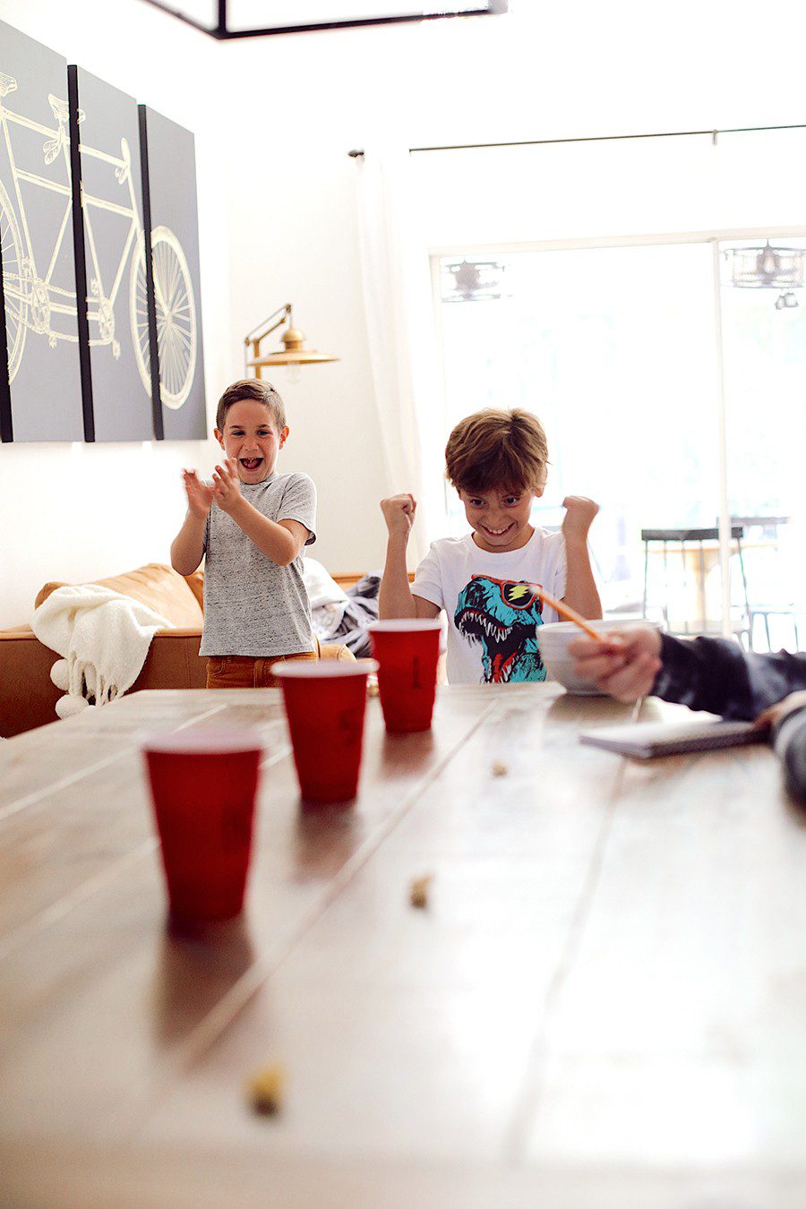 Popcorn toss and more fun popcorn games for family game night! | Family Fun Night by popular Florida lifestyle blog, Fresh Mommy Blog: image of some kids tossing popcorn into red plastic cups. 