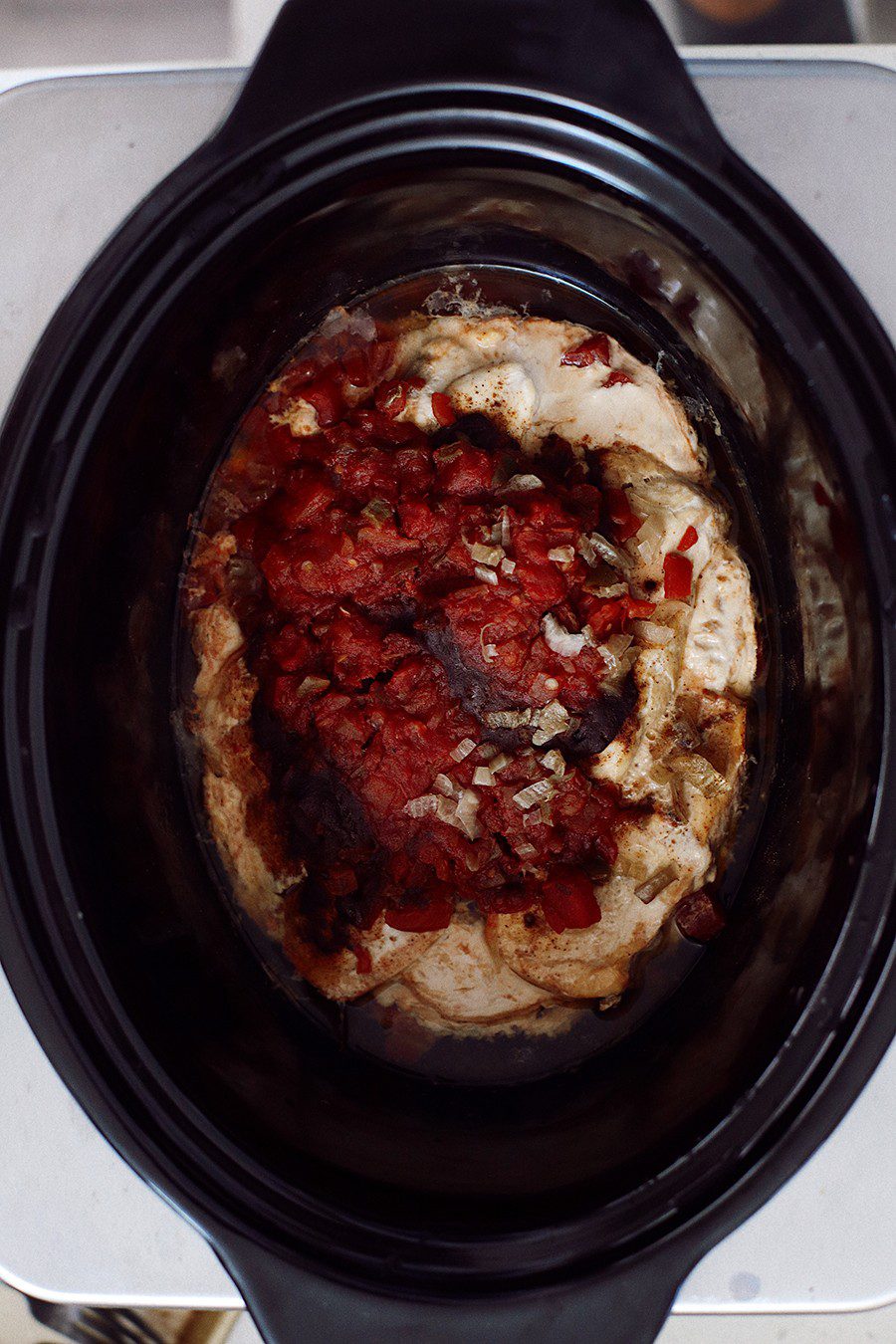 How to make an epic taco board and taco party platter tips! Plus, the best slow cooker taco chicken recipe! | Chicken Tacos by popular Florida lifestyle blog, Fresh Mommy Blog: image of raw chicken breasts, salsa, chopped onions, and spices in a slow cooker. 