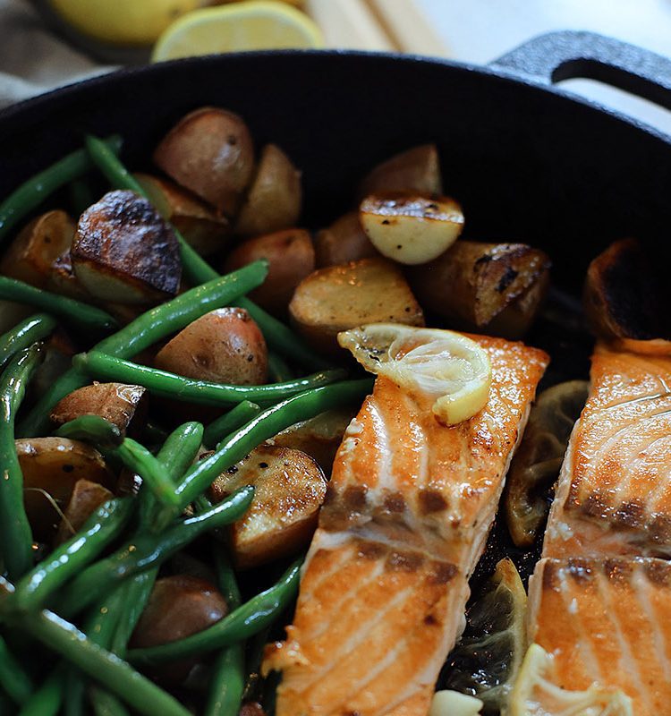 Wondering how to cook salmon? We've got such a simple and easy cast iron skillet salmon recipe with a delicious garlic lemon butter glaze. Pan seared salmon is an easy way to get it just right, every time… in fact, a kid can do it!