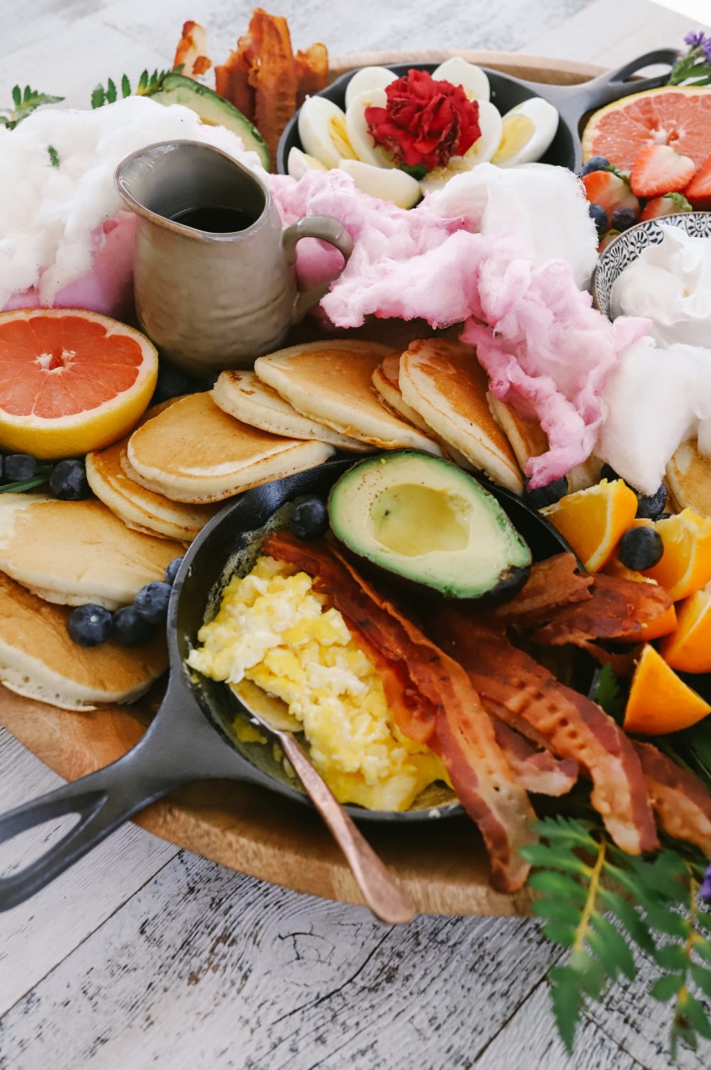 How to Make a Pancake Board That Looks as Delicious as It Tastes. The best Spring Breakfast Board |Pancake Board by popular Florida lifestyle blog, Fresh Mommy Blog: image of a pancake board with pancakes, grapefruit, blueberries, avocado, deviled eggs, bacon, scrambled eggs, and strawberries.